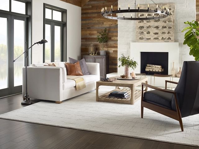 living room with dark hardwood flooring and a large white area rug from Pritchett's Flooring Design Center in the Colonial Heights, VA area