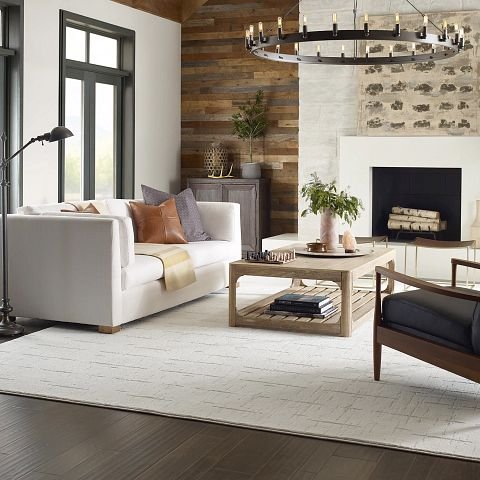 living room with dark hardwood flooring and a large white area rug from Pritchett's Flooring Design Center in the Colonial Heights, VA area