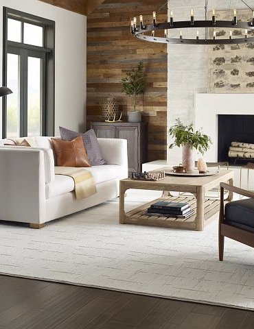 living room with dark hardwood flooring and a large white area rug from Pritchett's Flooring Design Center in the Colonial Heights, VA area